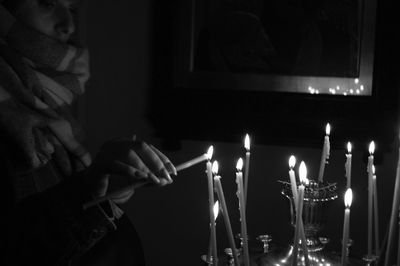Midsection of person holding illuminated candles