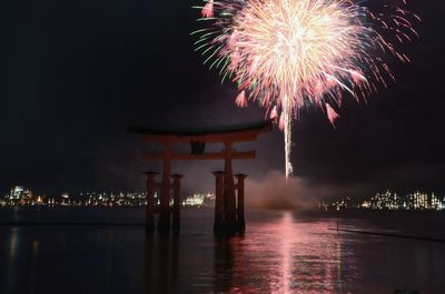 Torii gate with firework display in background