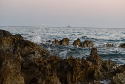 Scenic view of rocks in sea against sky