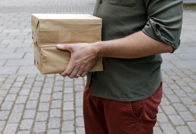 Midsection of man holding boxes