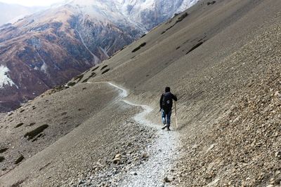 Rear view of men walking on mountain road