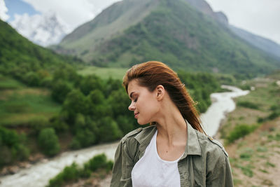 Portrait of young woman looking at mountains