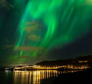 Scenic view of illuminated beach against sky at night