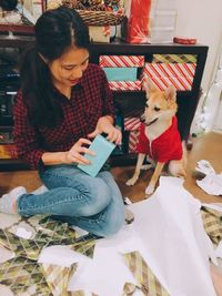 Young woman with dog sitting at home