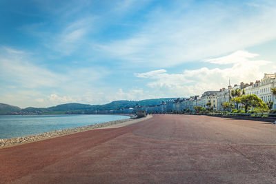 Road by sea against blue sky