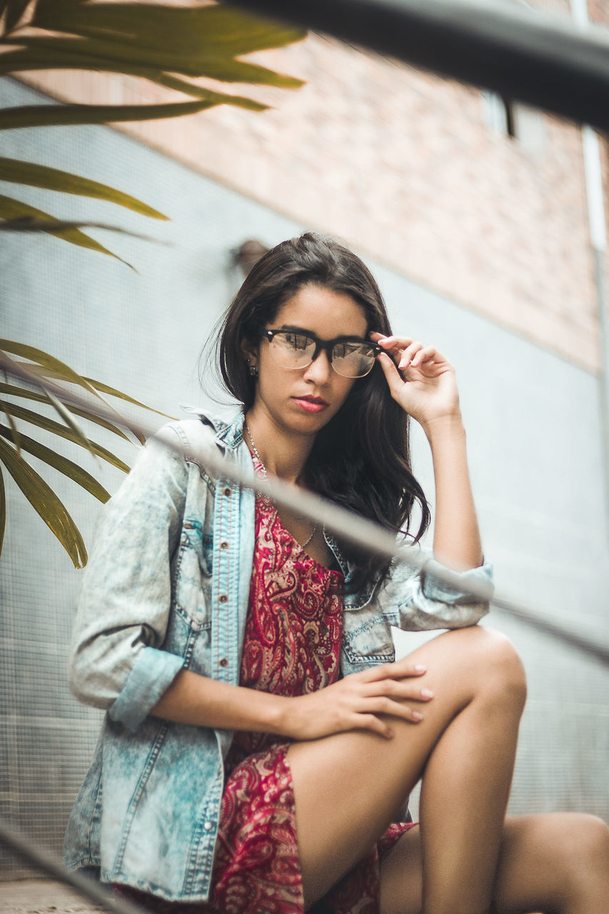 young adult, one person, young women, three quarter length, real people, lifestyles, casual clothing, front view, sitting, women, long hair, hair, leisure activity, focus on foreground, beauty, beautiful woman, adult, day, hairstyle, fashion, outdoors, contemplation