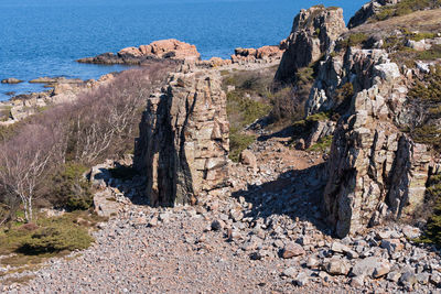 Rock formations on shore against sky