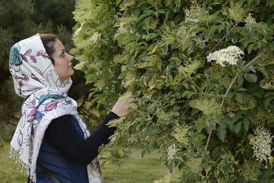 Side view of woman standing by plants