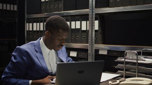 Side view of businessman using laptop at office