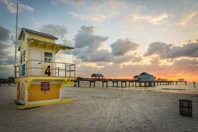 Lifeguard hut at beach against cloudy sky at dusk