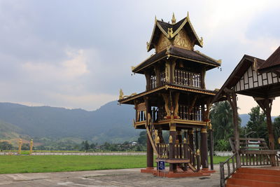 Traditional building by mountains against sky