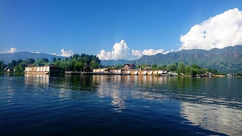 Scenic view of lake by mountains against sky