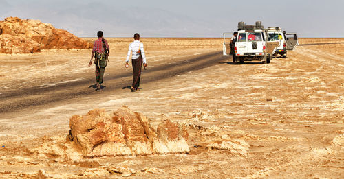 Rear view of people walking on road