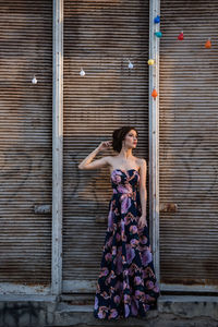 Full length of woman standing against wall