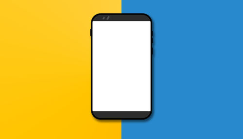 Low angle view of smart phone against blue background