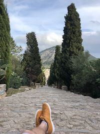 Low section of person on mountain against sky