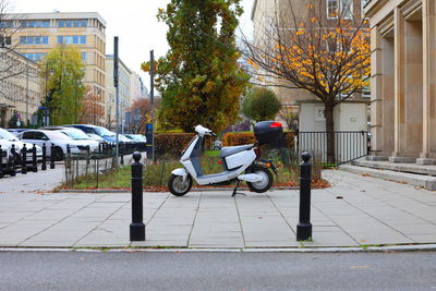 Bicycle on sidewalk by buildings in city