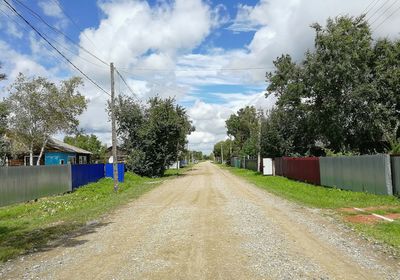 Road amidst field against sky