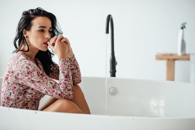 Beautiful woman sitting in bathtub