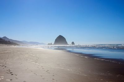 Scenic view of beach against clear blue sky