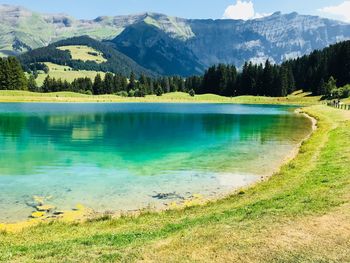 Scenic view of lake by mountains against sky