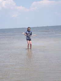 Portrait of woman standing in sea against sky