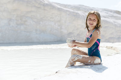 Portrait of young woman standing at beach