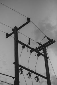 Low angle view of silhouette crane against sky