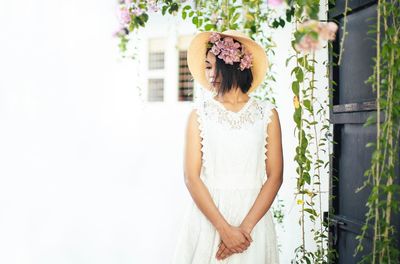 Woman standing against white wall