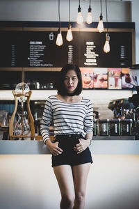 Portrait of woman standing at cafe