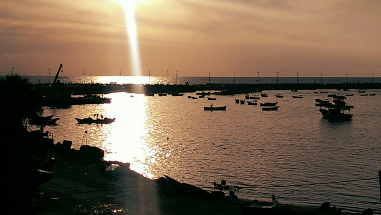 water, nautical vessel, sunset, transportation, sun, mode of transport, boat, sea, sky, reflection, sunlight, moored, waterfront, tranquil scene, silhouette, tranquility, scenics, beauty in nature, nature, sunbeam