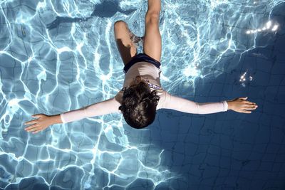 Directly above shot of boy jumping in swimming pool