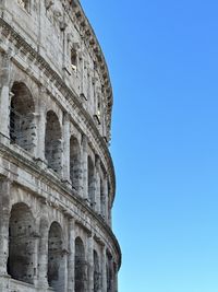 Partial view of the colosseum in rome with a blue sky as background 