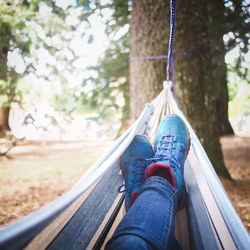 Low section of person relaxing on hammock