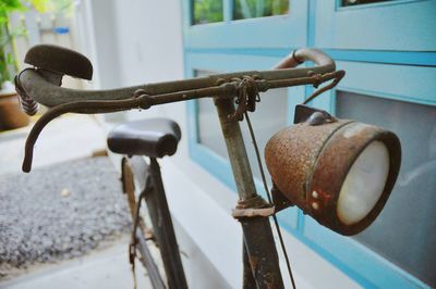Close-up of rusty bicycle against wall