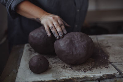 Middle-aged woman working in a pottery studio with clay