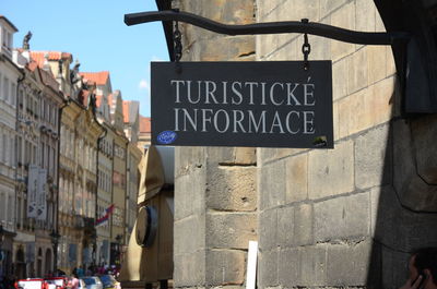 Low angle view of information sign on street against buildings