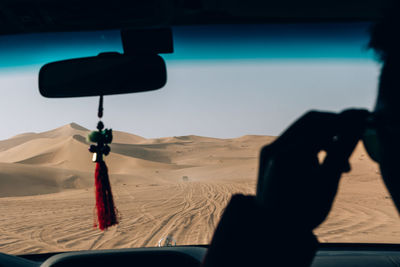 Cropped image of man in car at desert