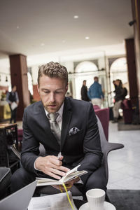 Businessman sitting in hotel reception reading document
