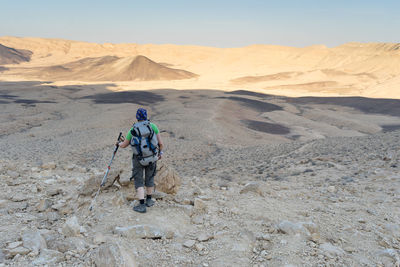 Full length of man climbing on arid landscape