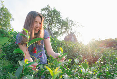 Young woman smiling amidst plants