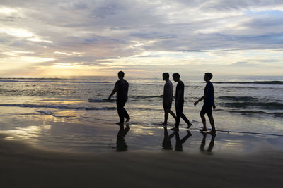 People at beach during sunset