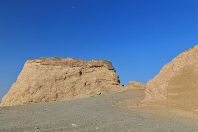 Rock formations against clear blue sky