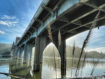 Low angle view of bridge over river against sky