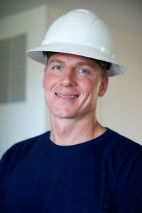 Portrait of confident smiling handsome man wearing white hardhat