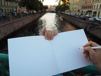 Midsection of person reading book on paper
