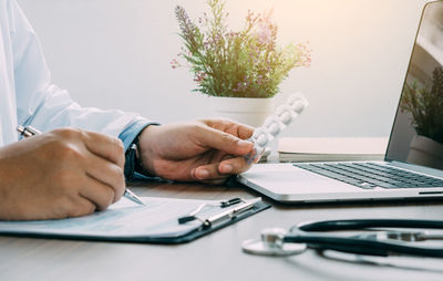 Midsection of man using laptop on table