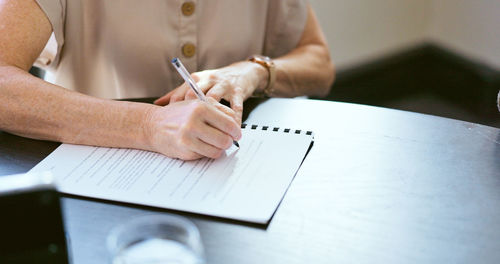 Midsection of businessman working on table