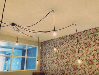 Low angle view of illuminated lamp hanging on wall