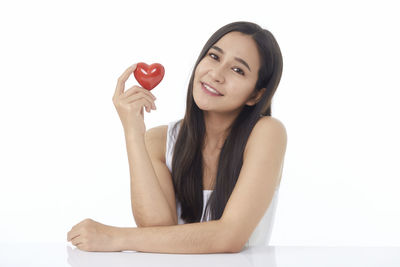 Portrait of a smiling young woman against white background